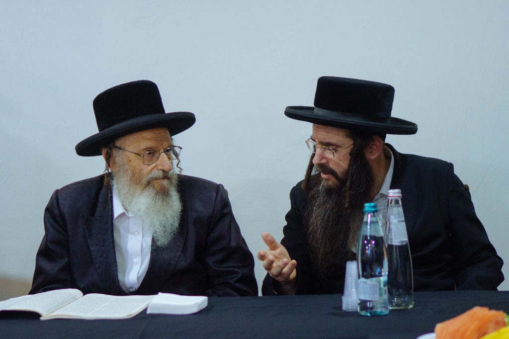 שניים מרבני ברסלב מדברים ליד שולחן